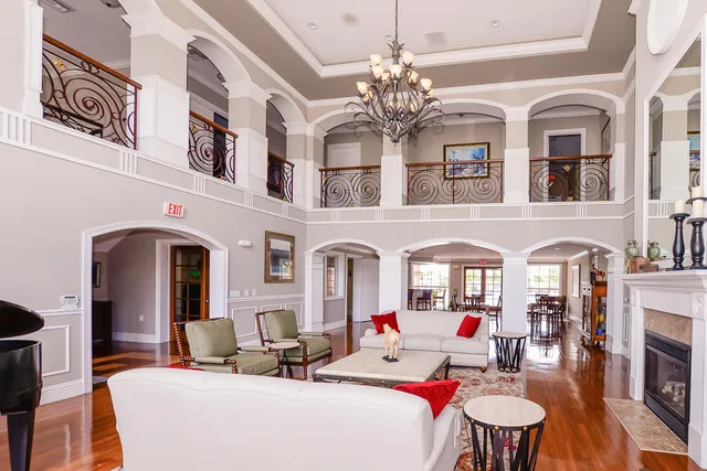 a living room with fireplace chandelier and breakfast area