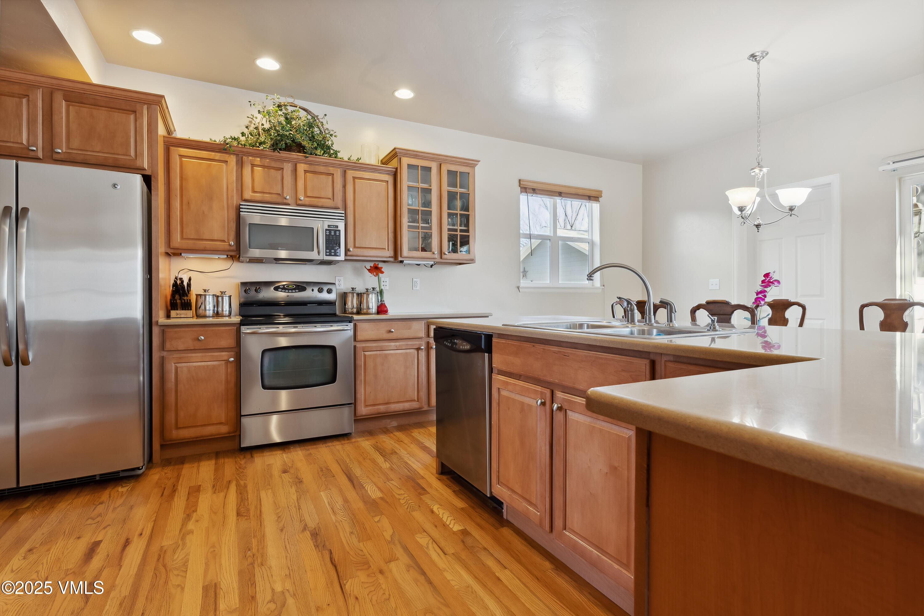 206 Mayer Street Eagle, CO 81631 - Photo 9 of 38 a kitchen with stainless steel appliances granite countertop a sink a stove a refrigerator and island with wooden floor