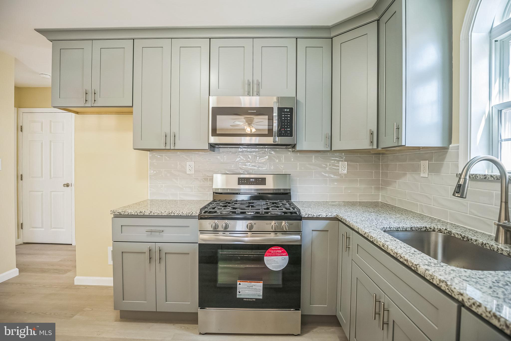 208 Hooker Street Riverside, NJ 08075 - Photo 8 of 25 a kitchen with granite countertop a stove sink and cabinets