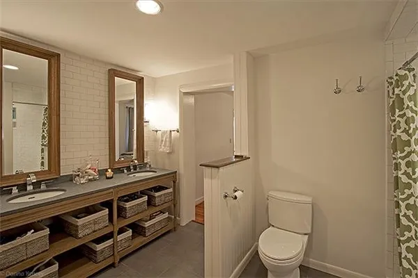 a bathroom with a sink a toilet a mirror and shower