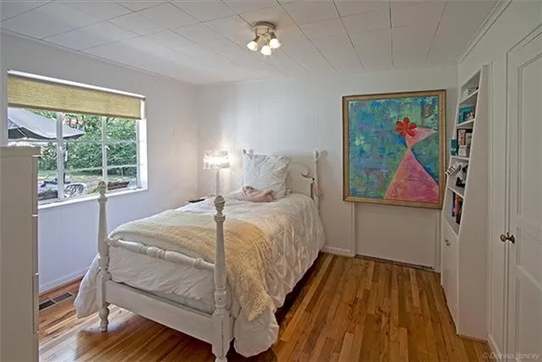 a bedroom with a bed and wooden floor