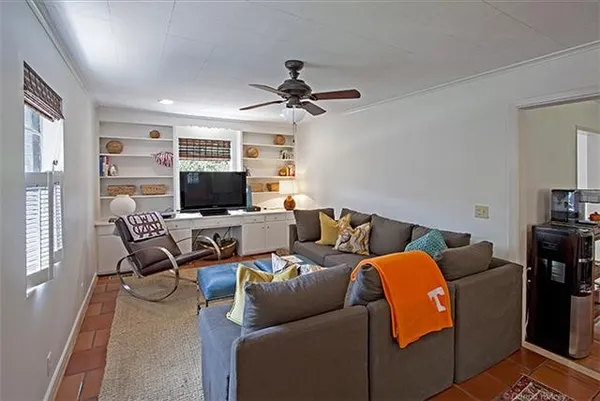 a living room with furniture a ceiling fan and a window