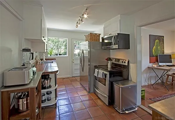 a kitchen with stainless steel appliances kitchen island granite countertop a stove refrigerator and microwave
