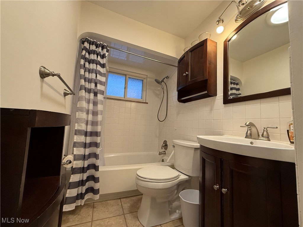 6290 Crossview Road Independence, OH 44131 - Photo 11 of 24 Full bathroom featuring tile walls, vanity, tile patterned floors, toilet, and shower / bath combo with shower curtain