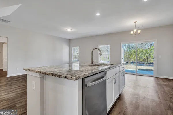 a kitchen with stainless steel appliances granite countertop a sink stove and cabinets