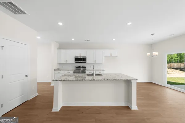 a large kitchen with stainless steel appliances granite countertop a stove a sink and a refrigerator
