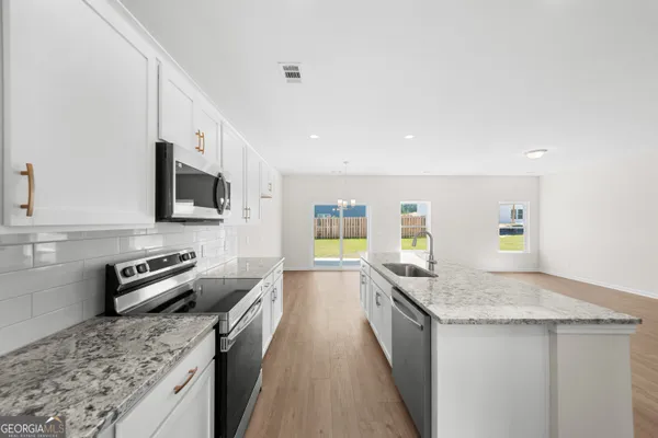 a kitchen with stainless steel appliances granite countertop a sink and a stove