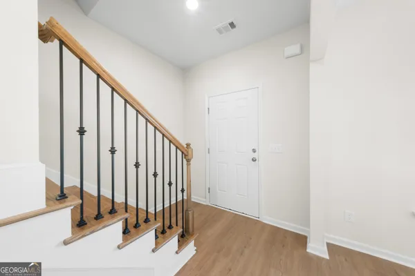 a view of a hallway with wooden floor and staircase