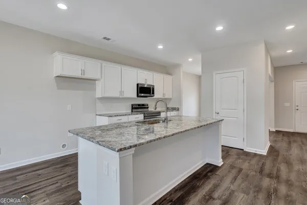 a kitchen with stainless steel appliances granite countertop a sink stove and cabinets