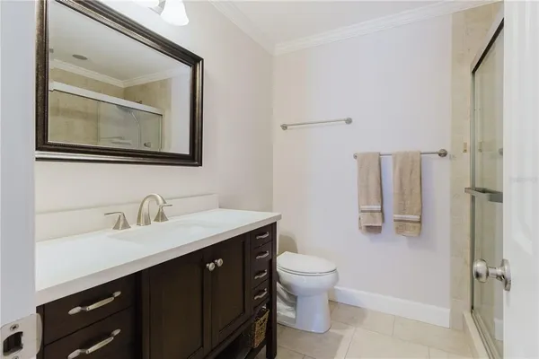 a bathroom with a toilet a sink a mirror and vanity
