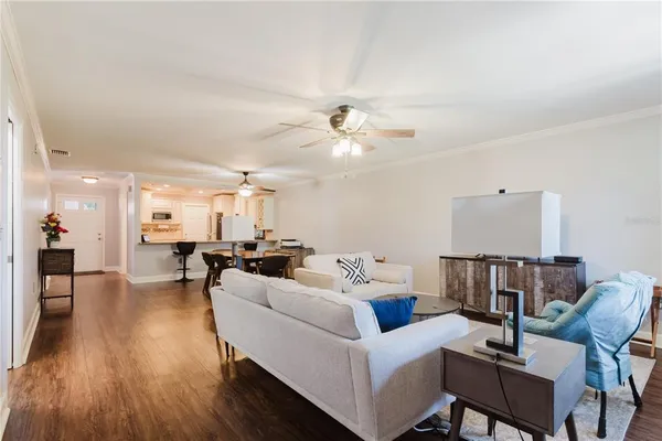 a living room with furniture a ceiling fan and a rug