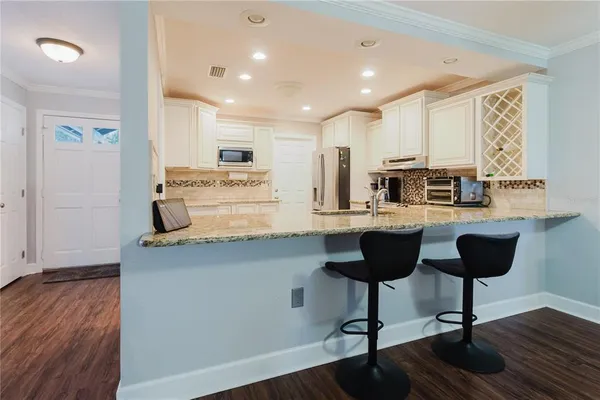 a kitchen with stainless steel appliances kitchen island granite countertop a stove a sink and a refrigerator