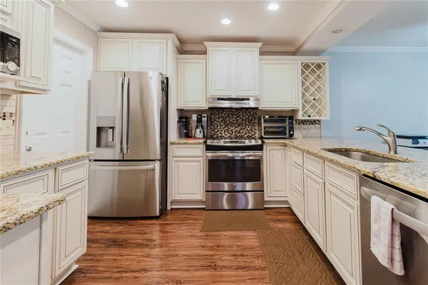 a kitchen with stainless steel appliances granite countertop a refrigerator and a stove top oven
