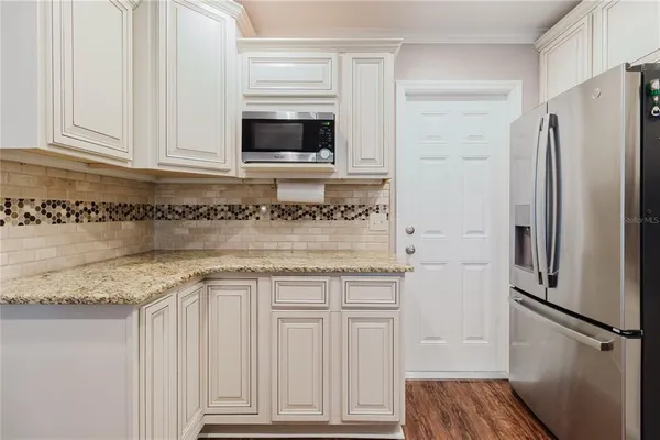 a kitchen with granite countertop a sink stove and refrigerator