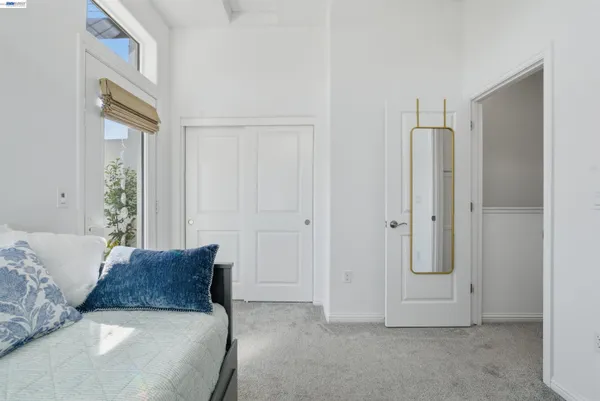 a spacious bedroom with a bed and a mirror