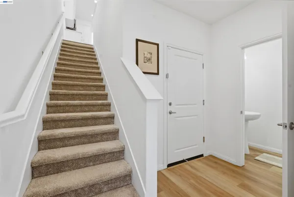 a view of a hallway with staircase and white walls