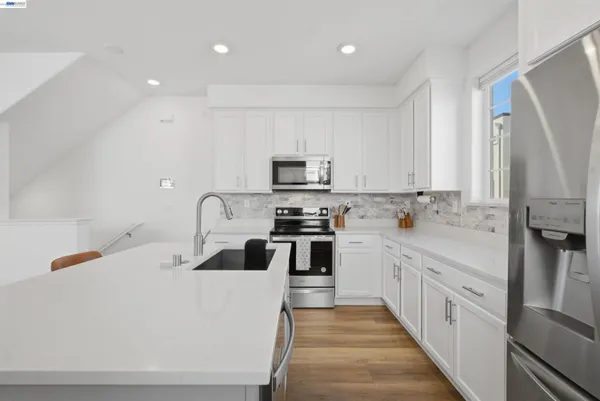 a kitchen with a sink a stove and cabinets