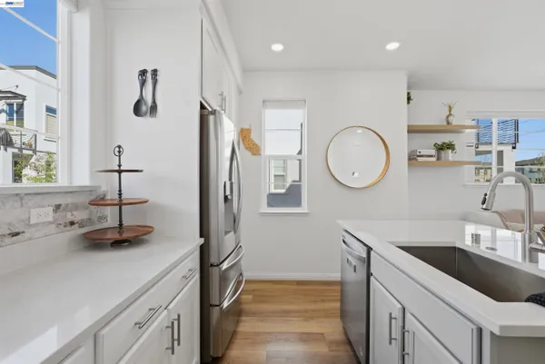 a kitchen with cabinets a sink and a stove top oven with wooden floor