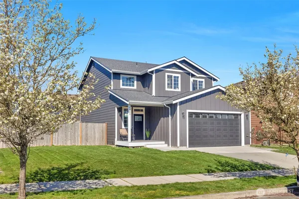 a front view of a house with a garden and yard