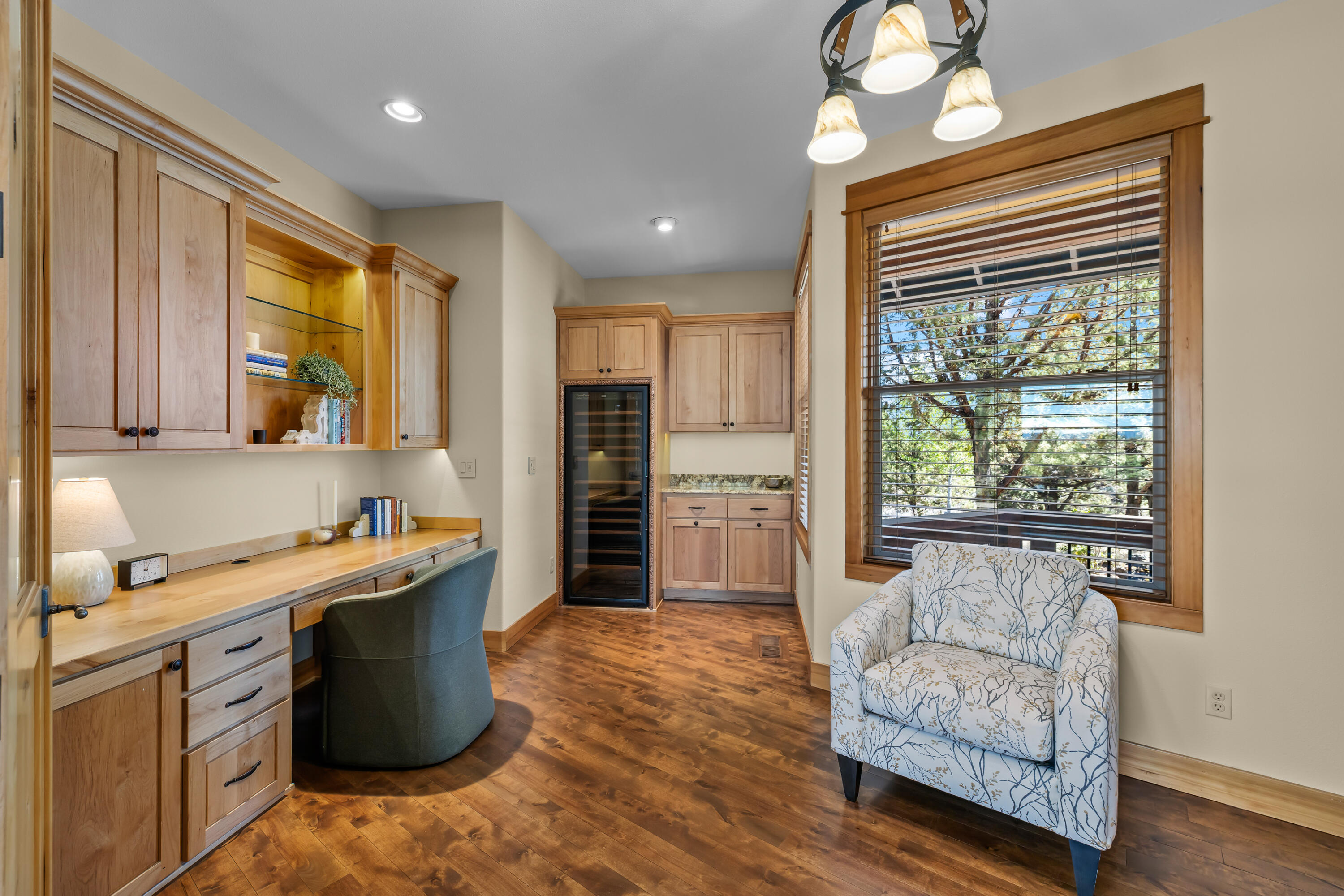 64145 Hunnell Road Bend, OR 97703 - Photo 29 of 65 Just off the dining and great room, the office provides a quiet transition between the primary suite and guest wing, with warm built-ins, a wine refrigerator and peaceful views of the natural setting.