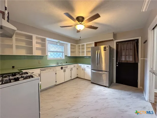 a kitchen with stainless steel appliances granite countertop a refrigerator and a stove top oven