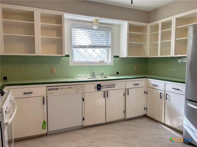 a kitchen with cabinets a sink and a window