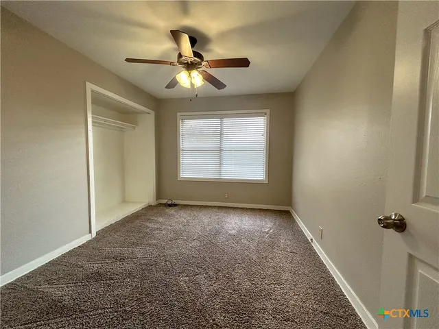 a view of a livingroom with a ceiling fan and window