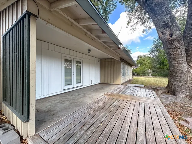 a view of backyard with a large tree and wooden floor