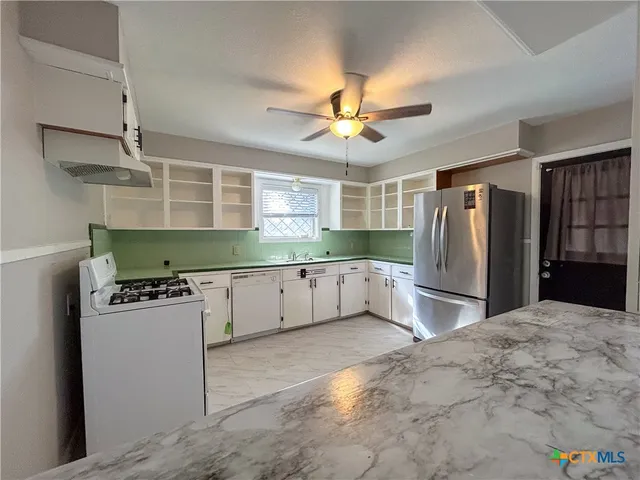 a kitchen with refrigerator and microwave