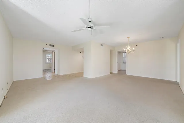a view of a big room with chandelier fan and windows