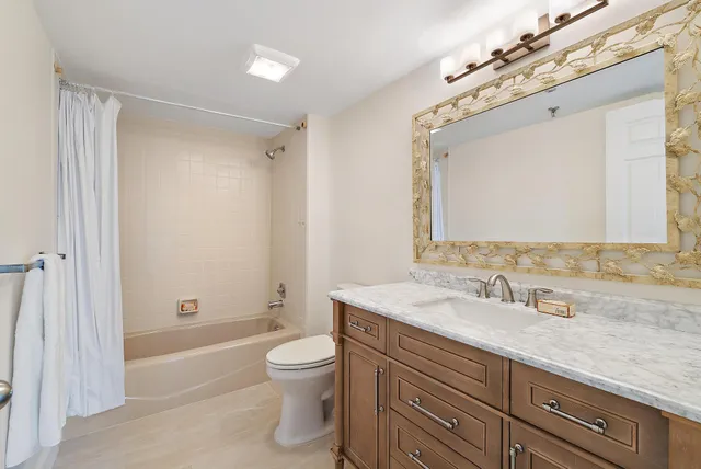 a bathroom with a granite countertop sink a toilet and shower