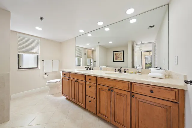 a spacious bathroom with a double vanity sink a mirror and a bathtub