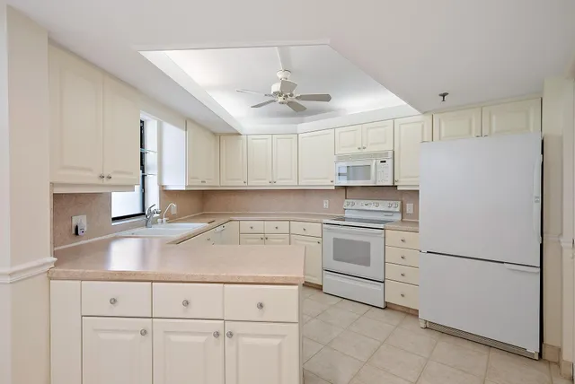 a kitchen with granite countertop white cabinets and white appliances