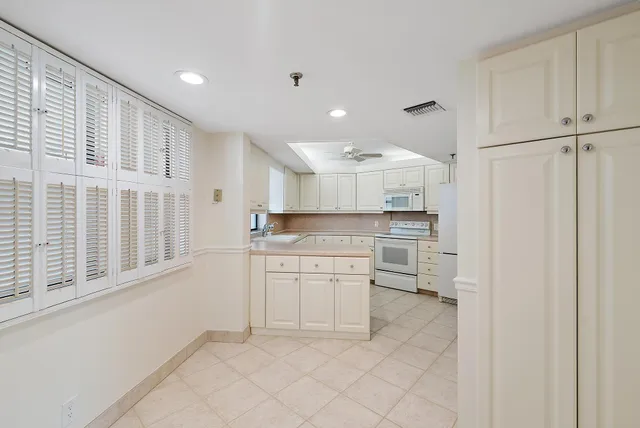 a kitchen with white cabinets and refrigerator