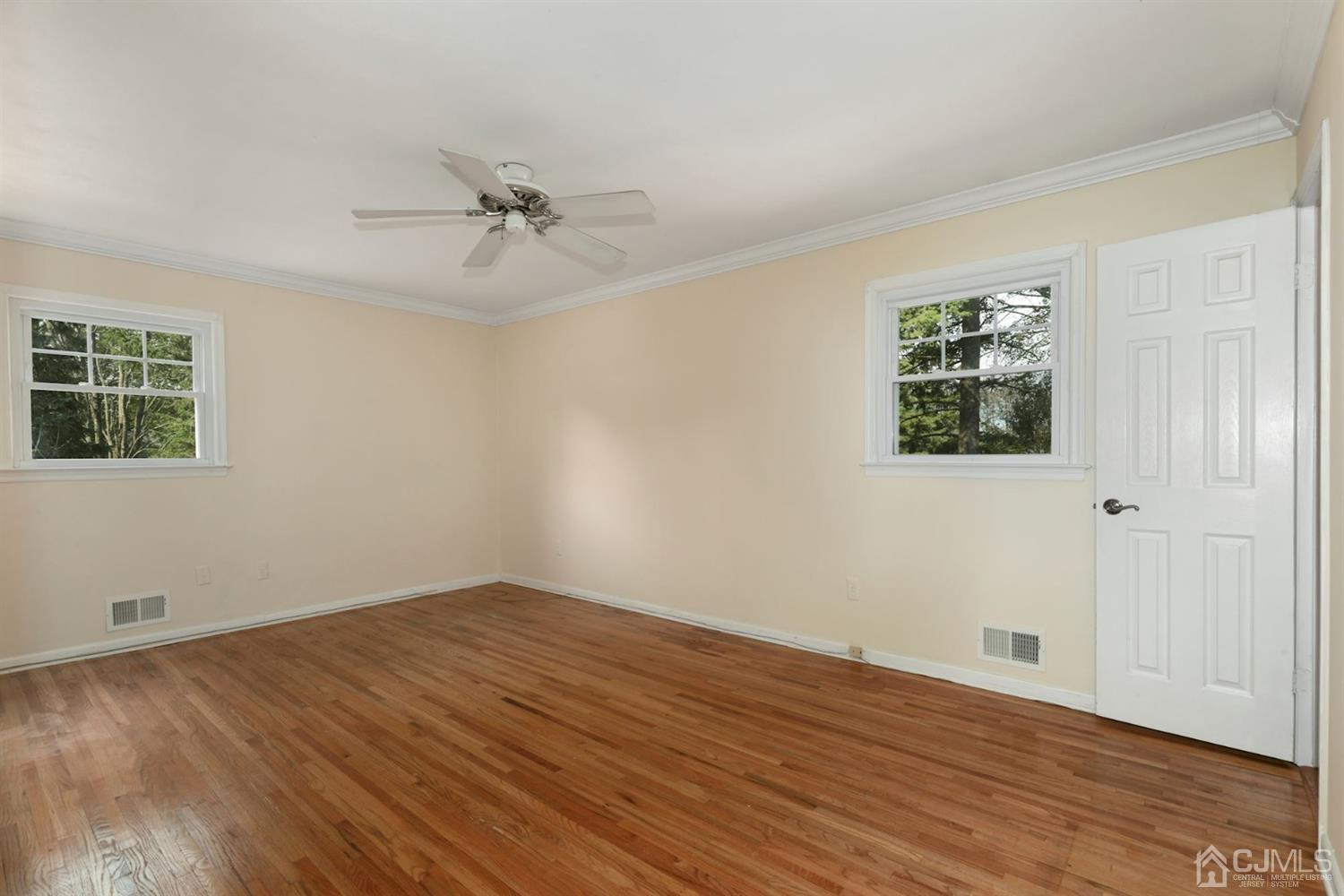 26 Donald Road East Brunswick, NJ 08816 - Photo 13 of 27 an empty room with wooden floor ceiling fan and windows