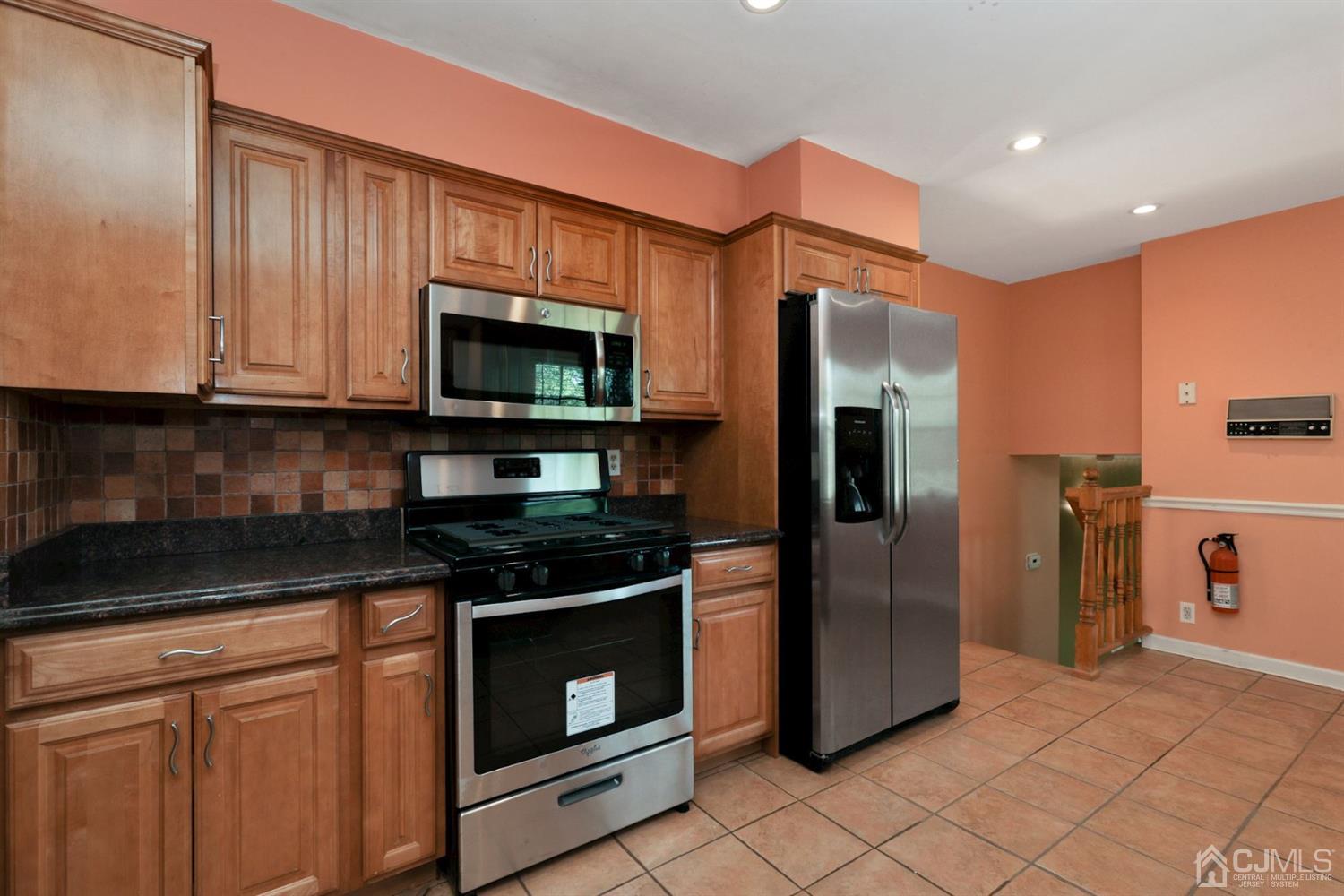 26 Donald Road East Brunswick, NJ 08816 - Photo 9 of 27 a kitchen with stainless steel appliances granite countertop a stove a refrigerator and a microwave