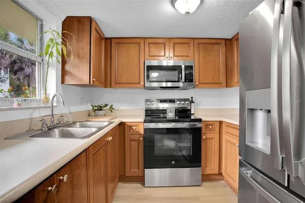 a kitchen with stainless steel appliances granite countertop a sink stove and refrigerator