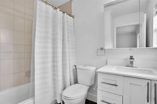 a bathroom with a sink a toilet and shower curtain