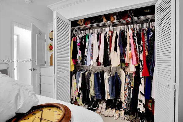 a view of walk in closet with clothes and shoes