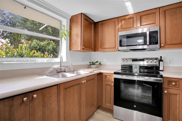 a kitchen with stainless steel appliances a stove a sink and a microwave