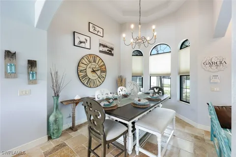 a view of a dining room with furniture a chandelier and wooden floor