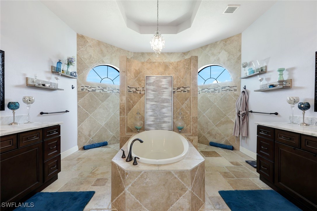 208 Southwest 15th Street Cape Coral, FL 33991 - Photo 17 of 50 a spacious bathroom with a tub sink mirror and a shower