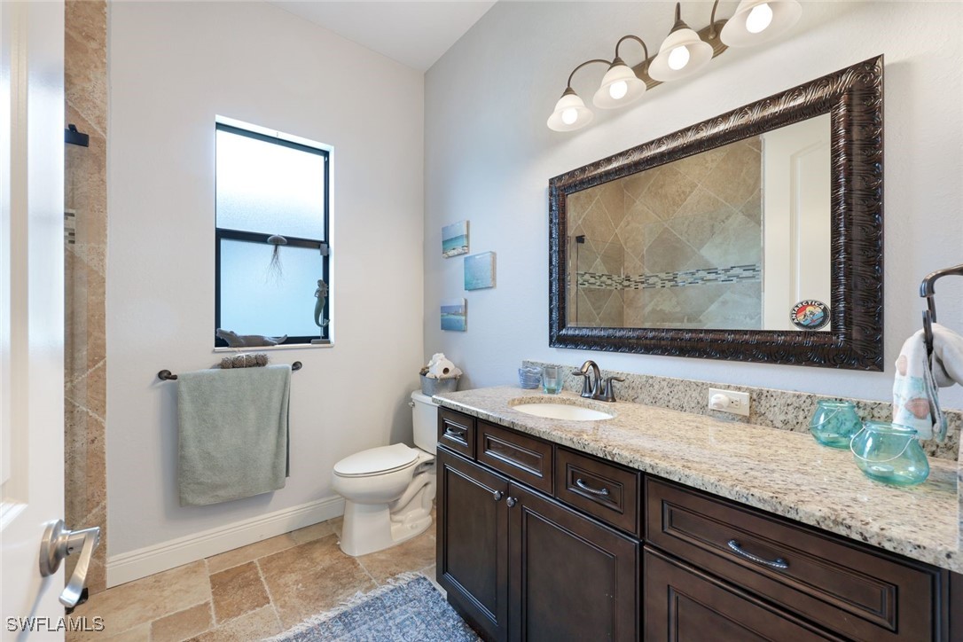208 Southwest 15th Street Cape Coral, FL 33991 - Photo 22 of 50 a bathroom with a granite countertop sink a toilet and mirror
