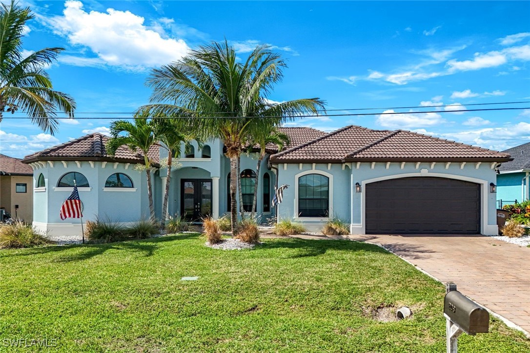 208 Southwest 15th Street Cape Coral, FL 33991 - Photo 3 of 50 a front view of a house with a yard and garage