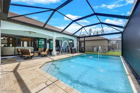 a view of a swimming pool with lawn chairs and floor to ceiling window