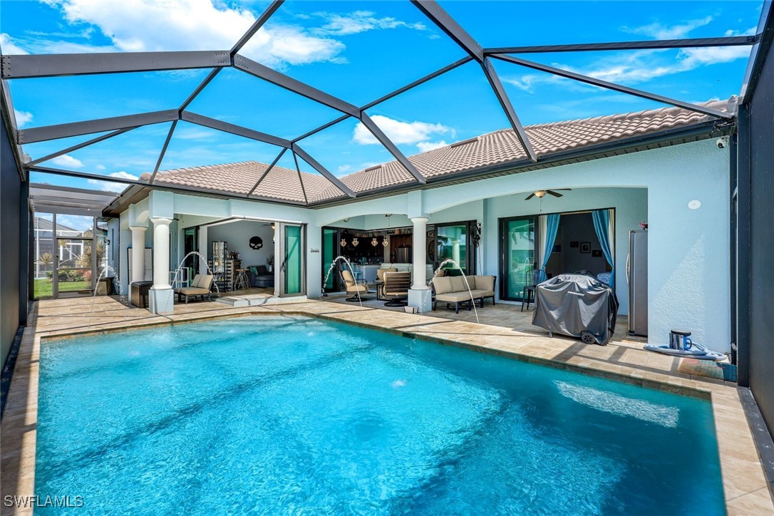 208 Southwest 15th Street Cape Coral, FL 33991 - Photo 32 of 50 a view of a swimming pool with lawn chairs and floor to ceiling window