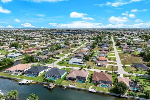an aerial view of residential houses with outdoor space and lake view in back