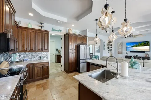 a kitchen with granite countertop a sink stainless steel appliances and cabinets