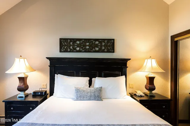 a bedroom with a bed and a lamp