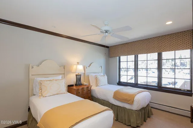 a bedroom with 2 bed and a large window